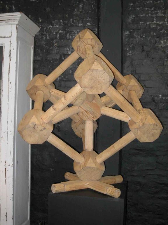 Very unusual wood sculpture of an atom. It has a very 3 dementional affect. It looks great from all angles.