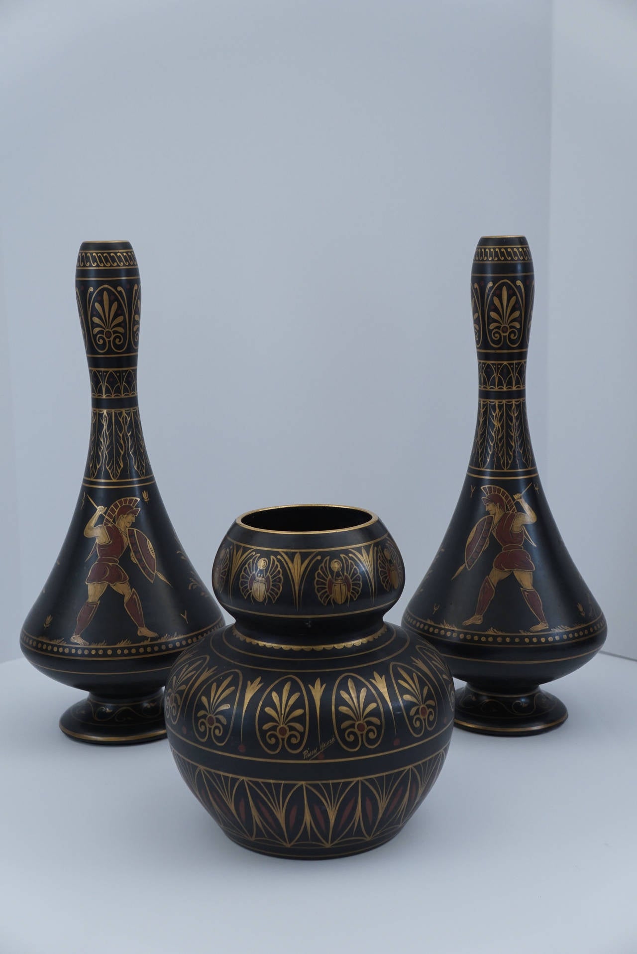 This unusual garniture was made in France and is marked correspondingly by the pottery company Alexander Bigot. Created from hand shaped terracotta which has been glazed then hand painted in gold and polychrome colors.  The painting is done in the