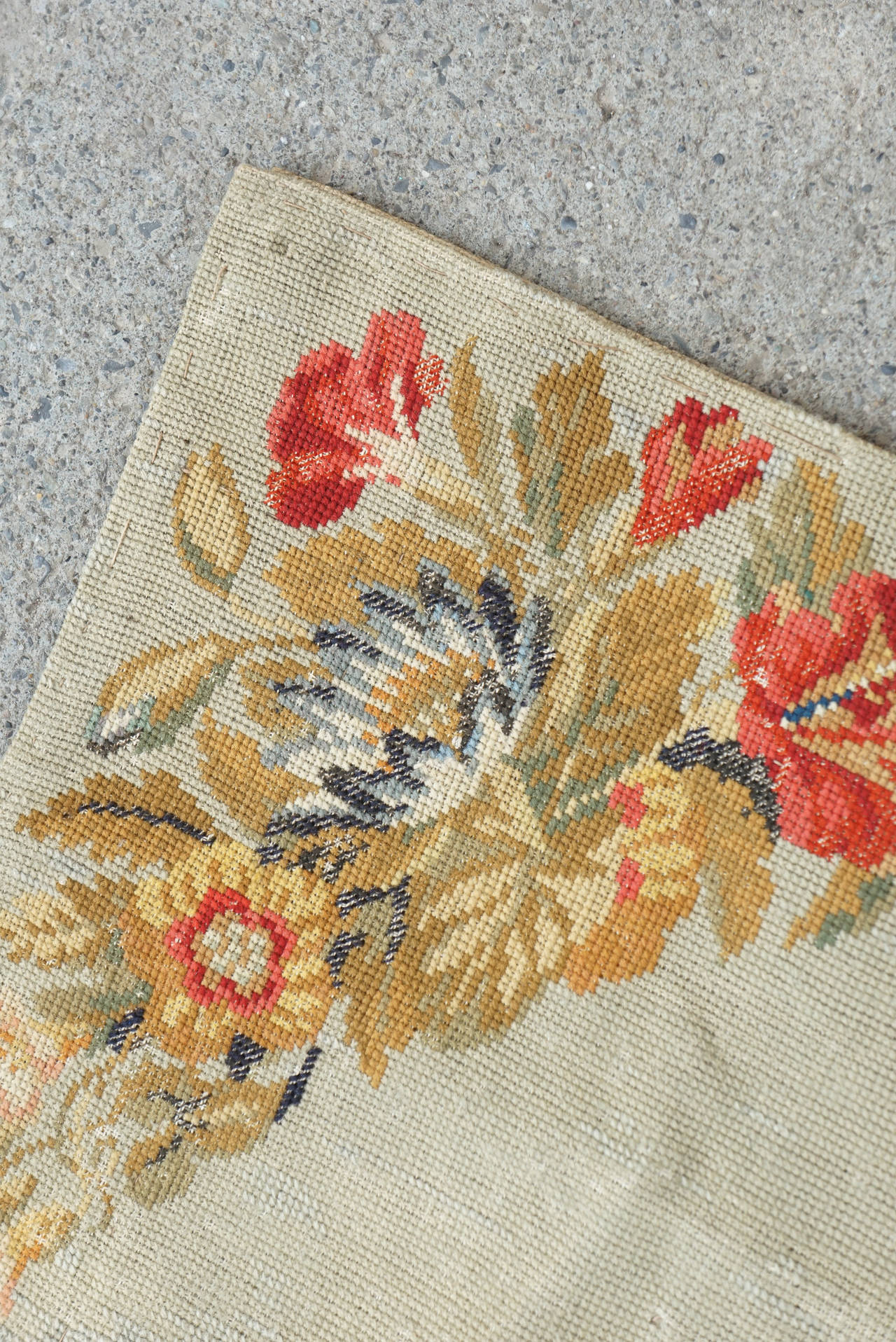 This fine old rug from the mid 19th century was made in England and retains many bright colors and details in the stitch patterns. Done in petit and gross point with woolen thread this rug is a fine example from an early period. The piece has