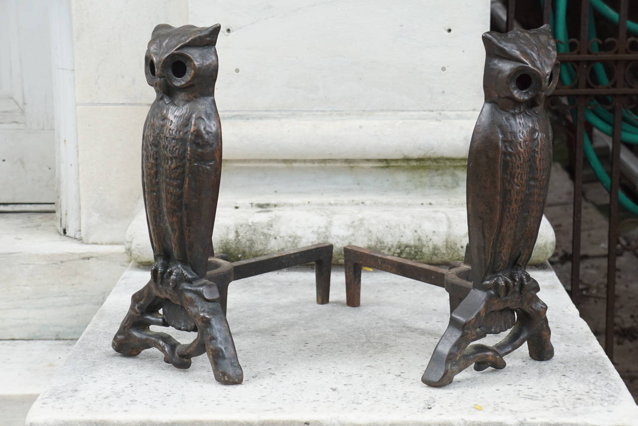 These fun and decorative andirons were made in America, circa 1915-1920. Made from iron that was then dipped in bronze and patinated giving them a rich and deep coppery color. Well cast with many details in the owl's body and wings the owls rest on