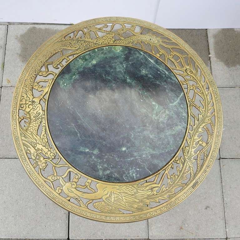 A lovely set of tables in a decorative filigreed dragon motif. The bases feature two dragons going face to face, while the top surface border features a dragon and bird. All metals are heavy castings, supporting  polished marble tops. Both tables