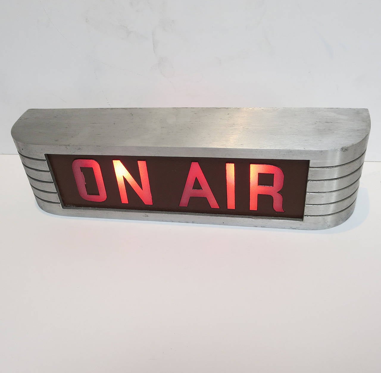In the early days of live radio and television, one had to make sure unwanted sounds were not captured on air. This warning lamp was mounted above a doorway to alert any employee or visitor that a live recording was in progress. The body of the sign