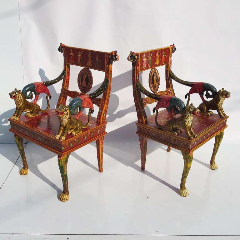 A very colorful statement, indeed! This great pair are hand carved, with arms of tigers and peacocks. The chair backs are embellished with elephant heads, and the front legs are designed to simulate animal legs. All surfaces are either carved,