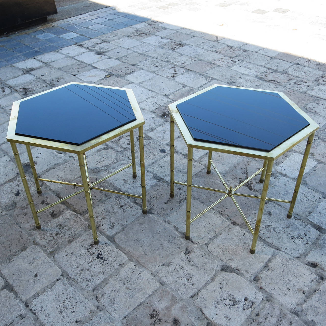 A Classic and versatile design, these handsome tables will be at home in a modern or more traditional setting. The legs and stretchers are created in a faux bamboo style, topped with a squared brass top. We have added new thick glass tops, finished