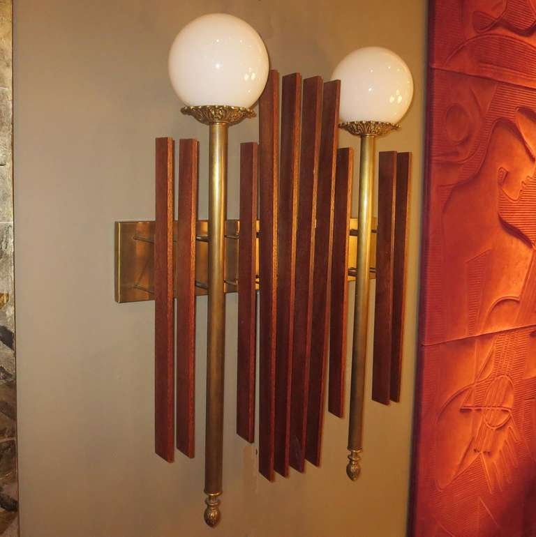 These fantastic lamps will add a bit of architectural sparkle to any interior setting! Slats of finished mahogany are suspended over a brass frame, interspersed by two brass and glass torch lamps. Both are in fine original working condition, and