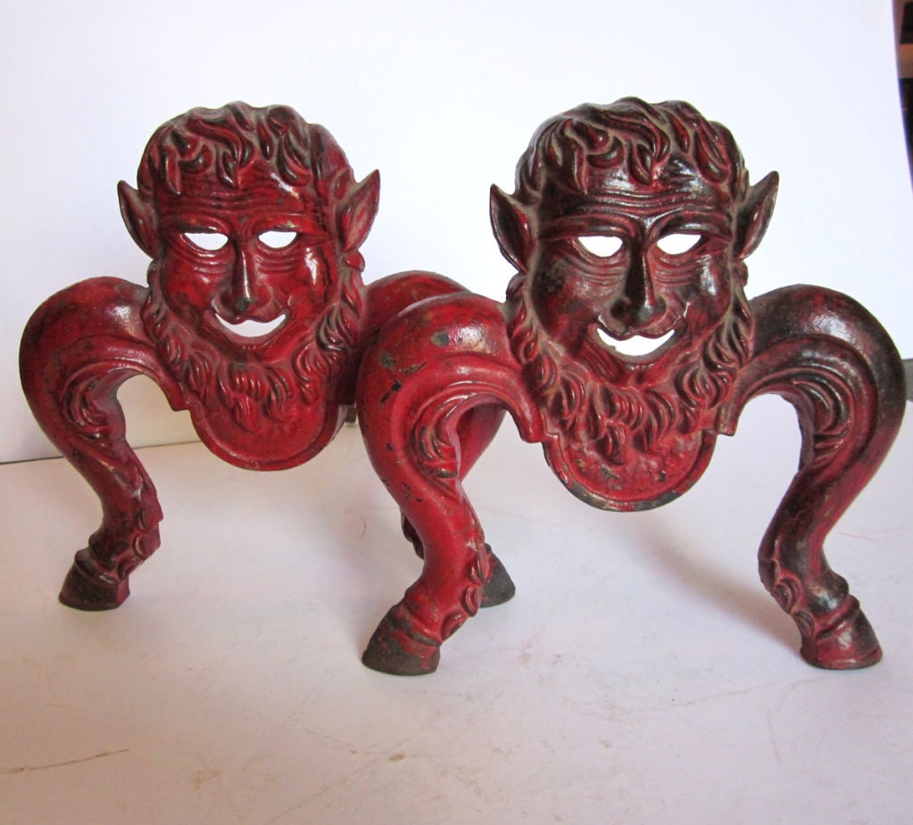 Imagine flames flickering behind these devilish faces - well, you get the connection!<br />
The pair are wonderfully cast in heavy iron, with appropriate paint wear for the age.