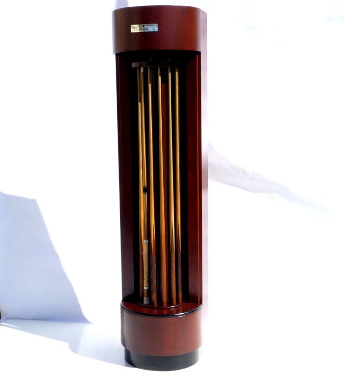 A fantastic streamlined design that ended far too soon! This rare refinished mahogany tower holds twelve of your favorite cue sticks in a stylish display. The center carousel freely revolves to access all cues. We have refinished the cabinet, and