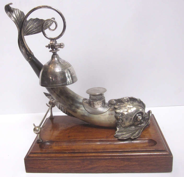 This incredible desk top diving dolphin inkwell was to have come from the desk of a ships captain of unknown origin. It is in very complete and fine condition, and includes the original bell striker. The body of the fish is a steer horn, mounted