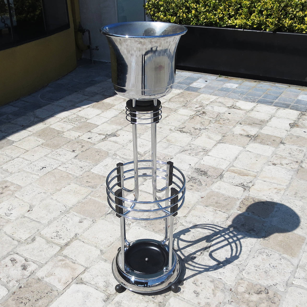 Add a touch of glamour to any room with this beautiful chromed stand. It could be utilized as a plant stand and umbrella stand in an entryway, or as a table side wine or champagne holder. The chrome is in great original condition and displays