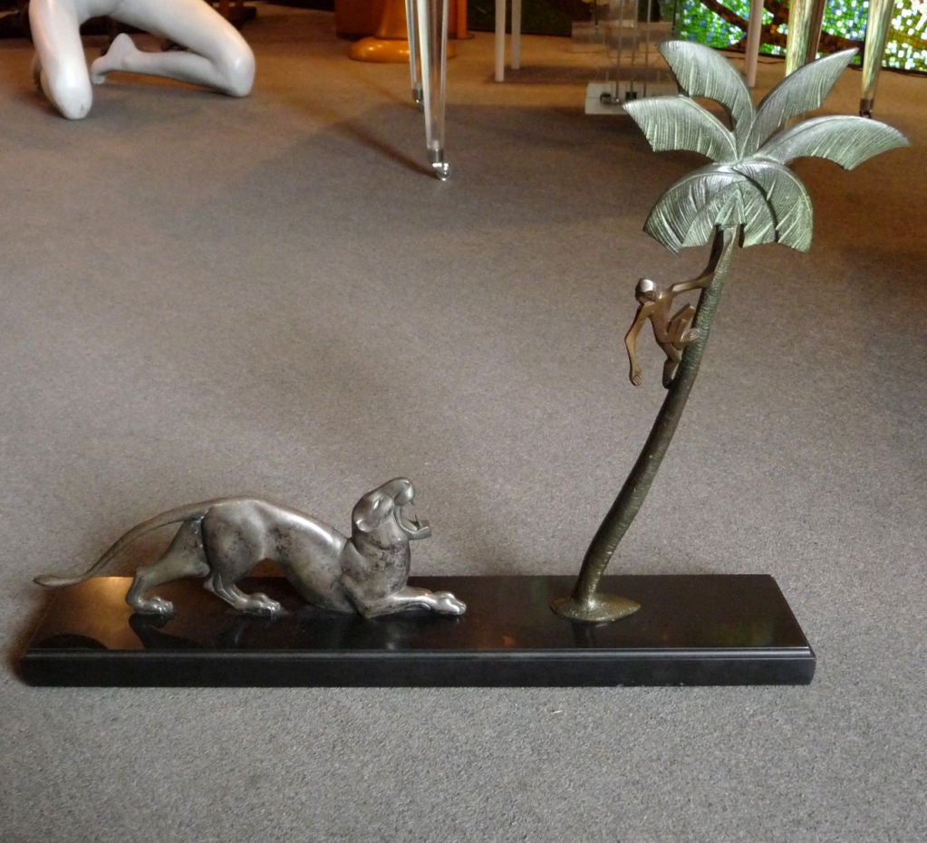 This fantastic bronze depicts a snarling tiger, who has cornered a monkey up a palm tree. All figures are ultra stylized in a cubistic fashion, and display beautifully from both sides. The tiger is in a silver plated bronze, while the monkey and