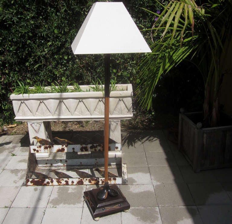 This lamp most likely graced the clubhouse of an early golf course, and is full of charm. Three wooden drivers are joined to form the shaft, standing over a finished wooden base. Each side of the base is decorated with high relief crossed clubs,