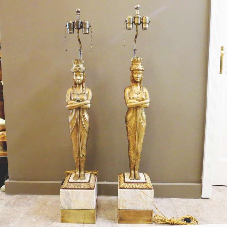 This lovely pair are in fantastic condition, and have just been completely retro fitted and rewired. The bodies are gilded plaster, standing over bases of marble and brass. Both standard sockets have individual pull chains, and cord is gold silk. We