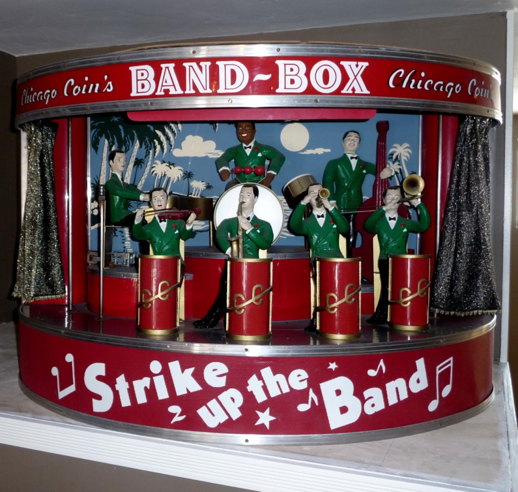 The Band Box, a mini orchestra in a cabinet, was developed to help bar owners collect more jukebox revenue. The cabinet hung on the wall, lights out and curtains closed. As soon as a song was played on the jukebox, the curtains opened, lights came