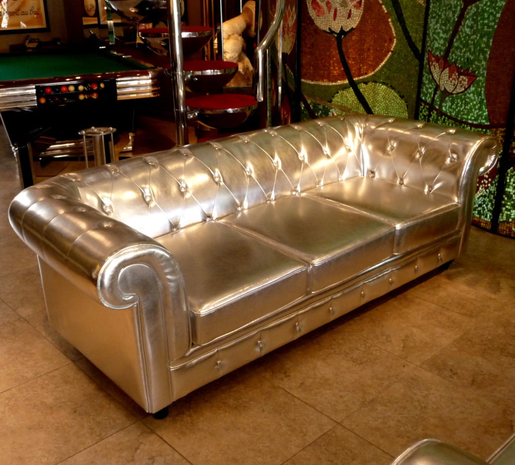 In keeping with the bigger than life personalities of America's favorite family, the furniture they decorated with was just as grandiose. This pair of Chesterfield styled sofas are covered in the most amazing silver leatherette, and are nothing