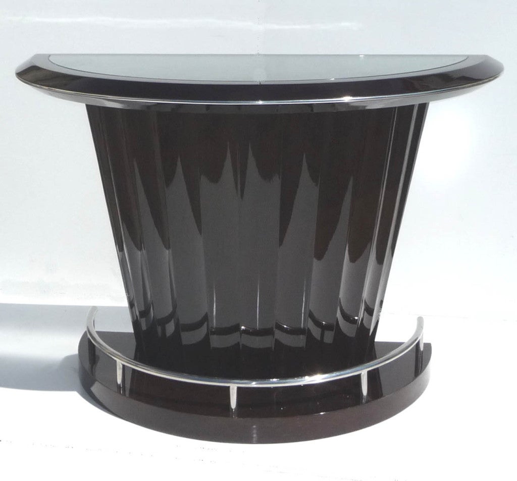 This very stylish bar was created in the manner of Ruhlmann and other 1930's French designers. It is quite heavy and solid, with a heavy gloss finish over walnut. There is visible wood grain throughout, although it appears almost black in some of