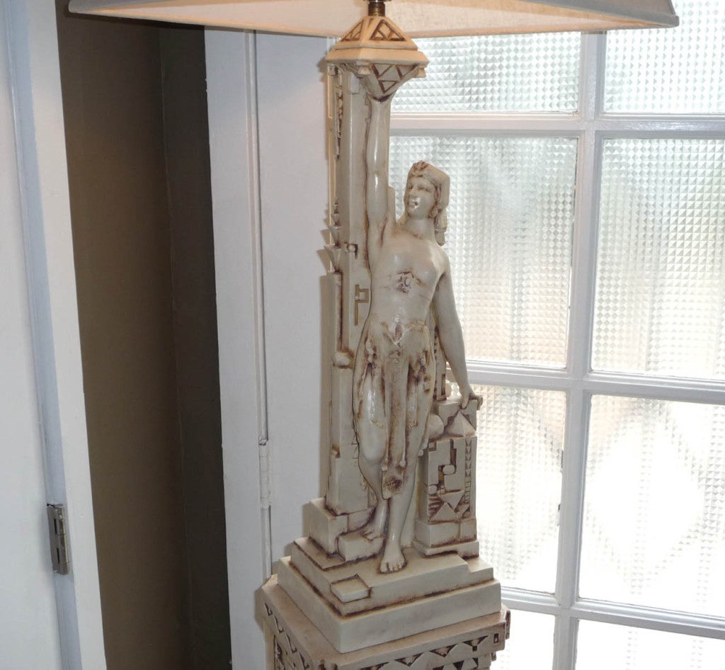 The lamp and pedestal, although almost identical in form, were designed by two artists. The female form lamp was designed by Fritz Albert, while the base was designed by Fernand Moreau. Both began careers with the Gates Pottery Company of Chicago,