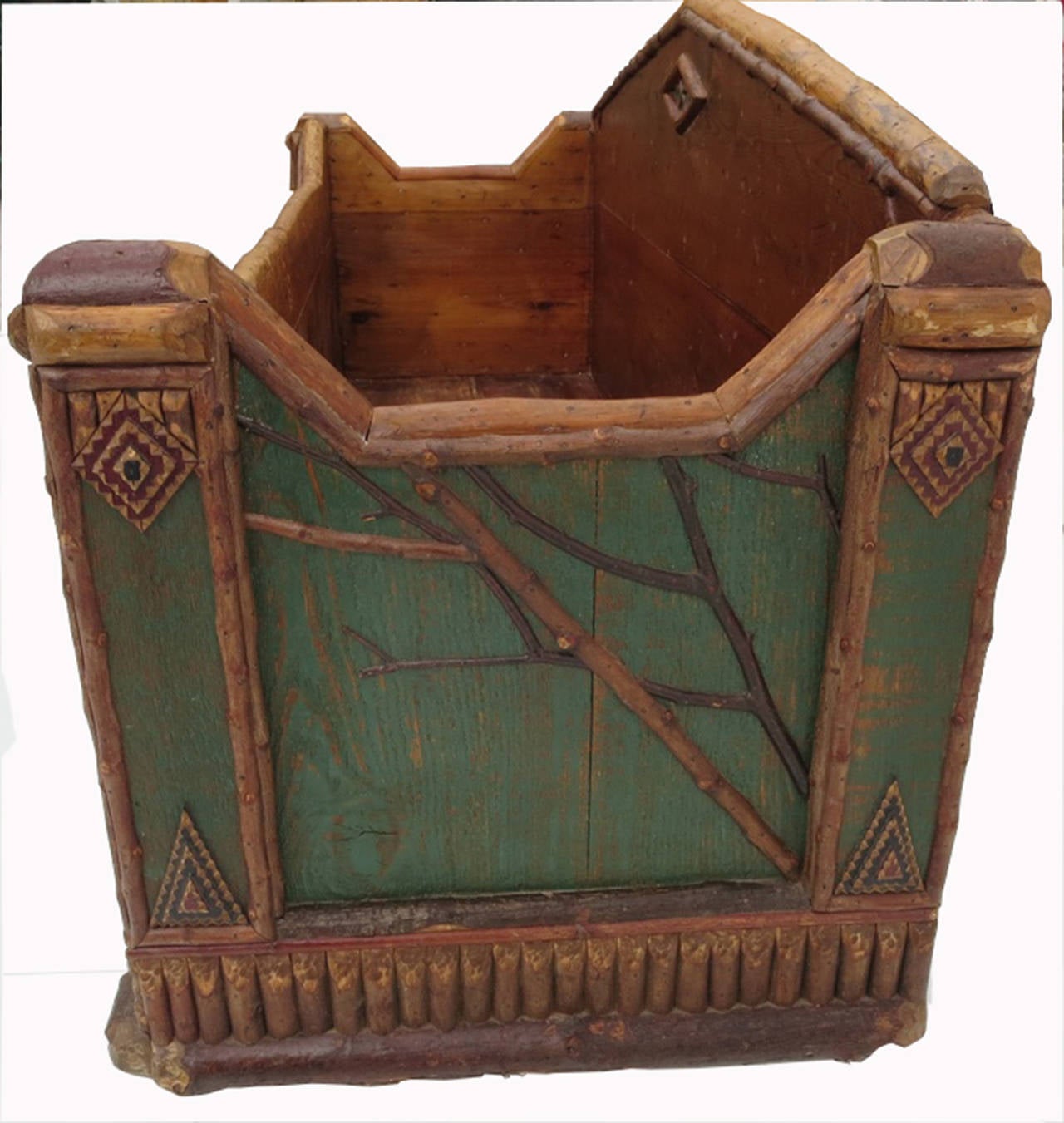 An incredible example of American rustic style, this painted wooden log receptacle is certainly influenced by the works of Thomas Molesworth. Delicate tree branch forms adorn the front and sides of the box to great effect. The base and feet are