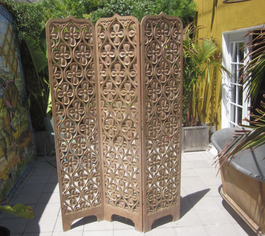 This lovely screen is solid mahogany, all hand carved, and displays beautifully. It was once painted white, and a sheen of the old finish still appears, as well as remnants of the old finish. It is in fine condition, without any structural issues. 