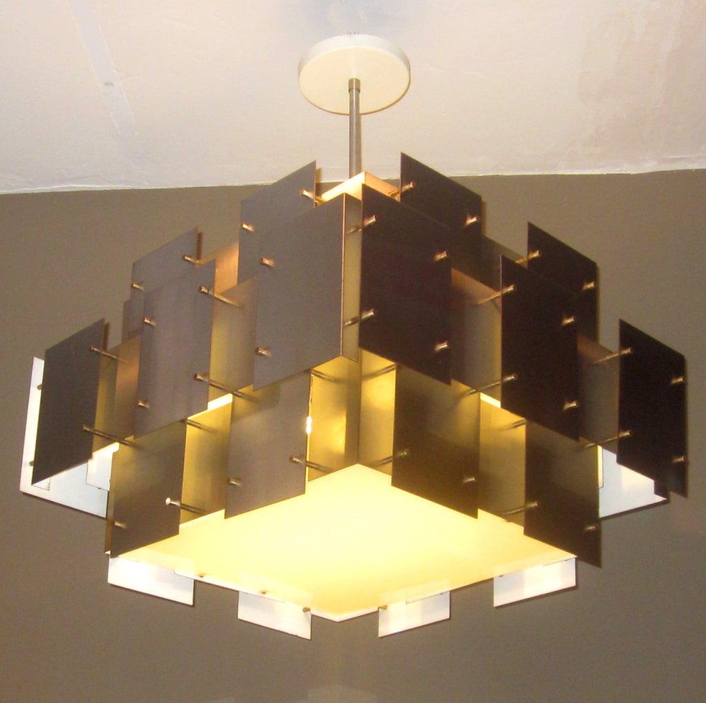 A lovely design by Robert Sonneman, this cubist fixture is similar to many of the Sciolari lamps. Ours is lacquered steel flat and right angled panels, raised to varying depths by brass rods and tapered caps. The insides are painted white for