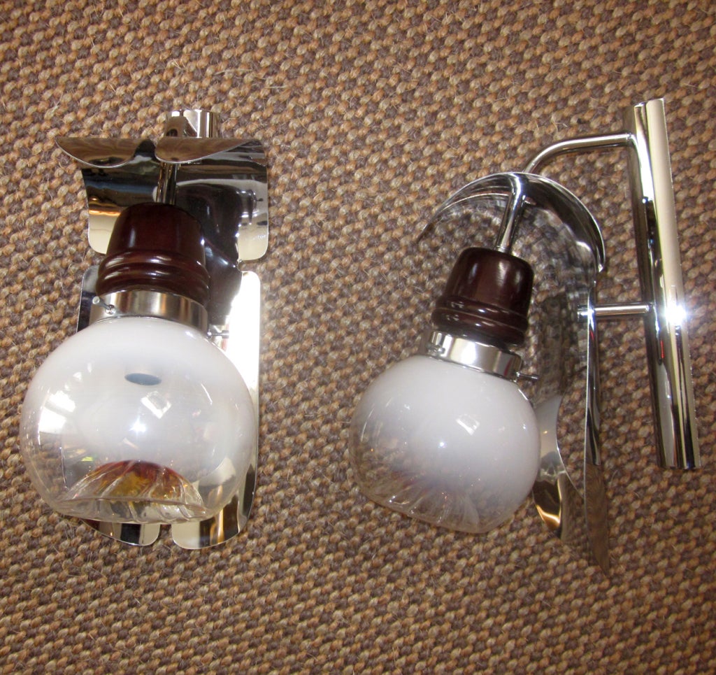 A very smart design in excellent original condition, this pair of Italian wall lamps were made by the Mazzega lamp works. The Murano glass globes transition from amber to clear to milk glass. They are set into a holder of chrome and dark wood, and