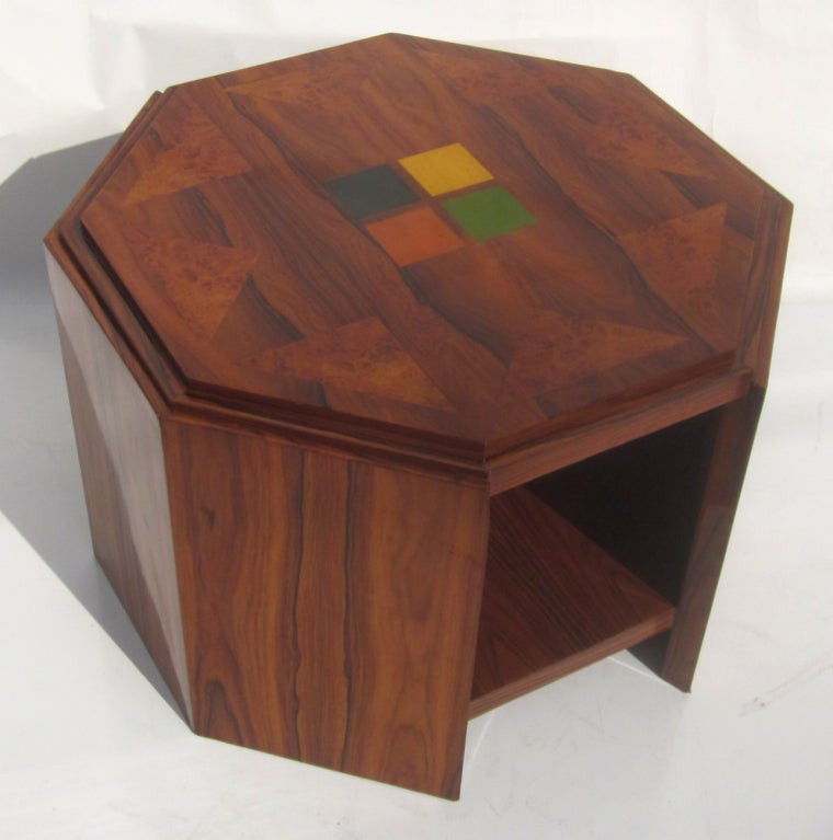 This lovely table features beautifully grained walnut, with inlaid triangles of burled woods in the top. Of interesting note is the painted center design of colored squares. The octagon shaped sides step down, adding another simple, yet effective