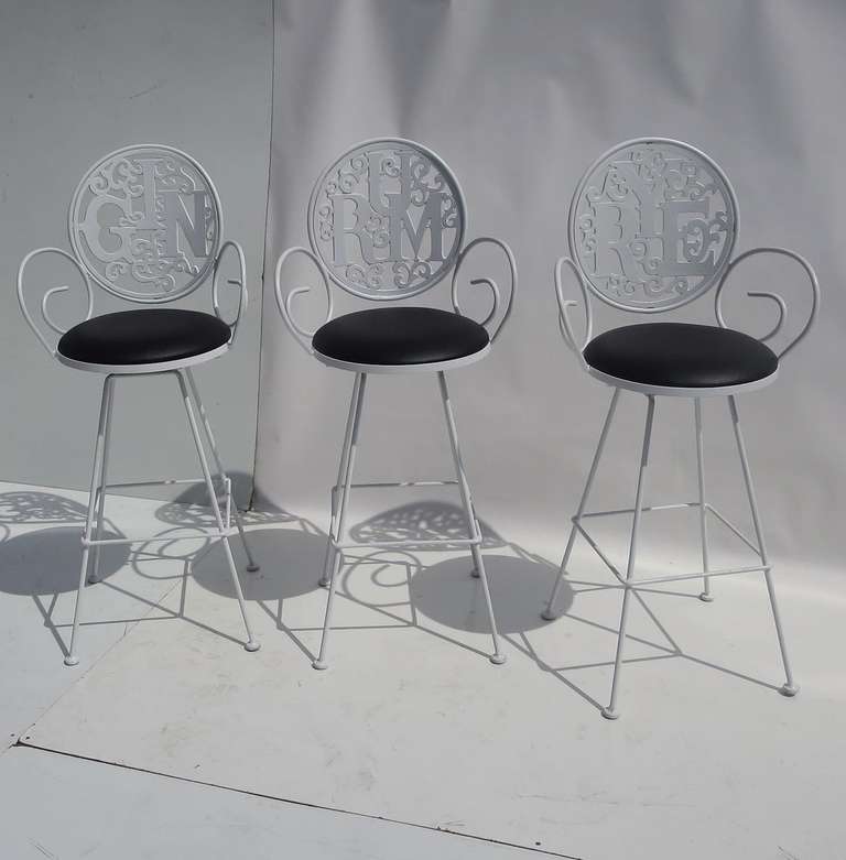 Pick your drink, and pick your seat! These metal barstools say it all! Created in a Pop Art style, these recently came from a Palm Springs estate. The chairs are painted steel frames, with a cast aluminum back. All stools have been re-painted white,