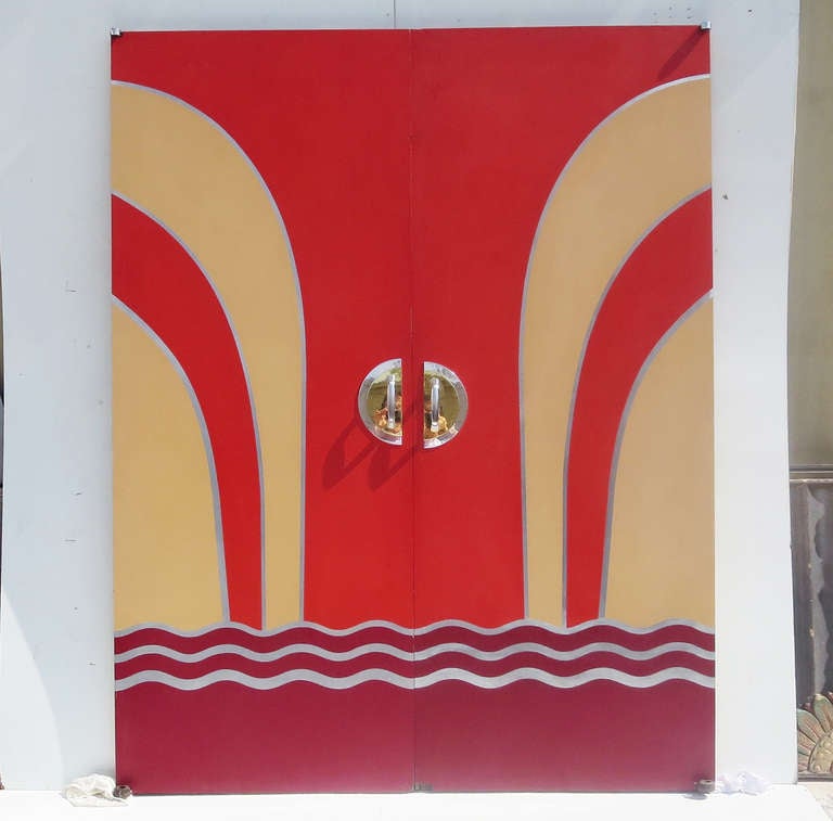 The ultimate screening room doors! These solid doors, taken from a 1930's Florida movie theater, are fantastic in laminate with inlaid metallic designs. One side has handles for pulling open, and the reverse sides have push plates. They are in nice