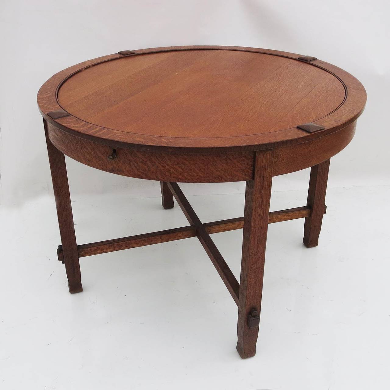 A great table by an unknown maker, the work is similar to Stickley or Limbert furnishings of the same period. The table is executed in highly flamed quarter sawn oak, in a pleasing original satin finish. With the pull of the side mounted knob, the