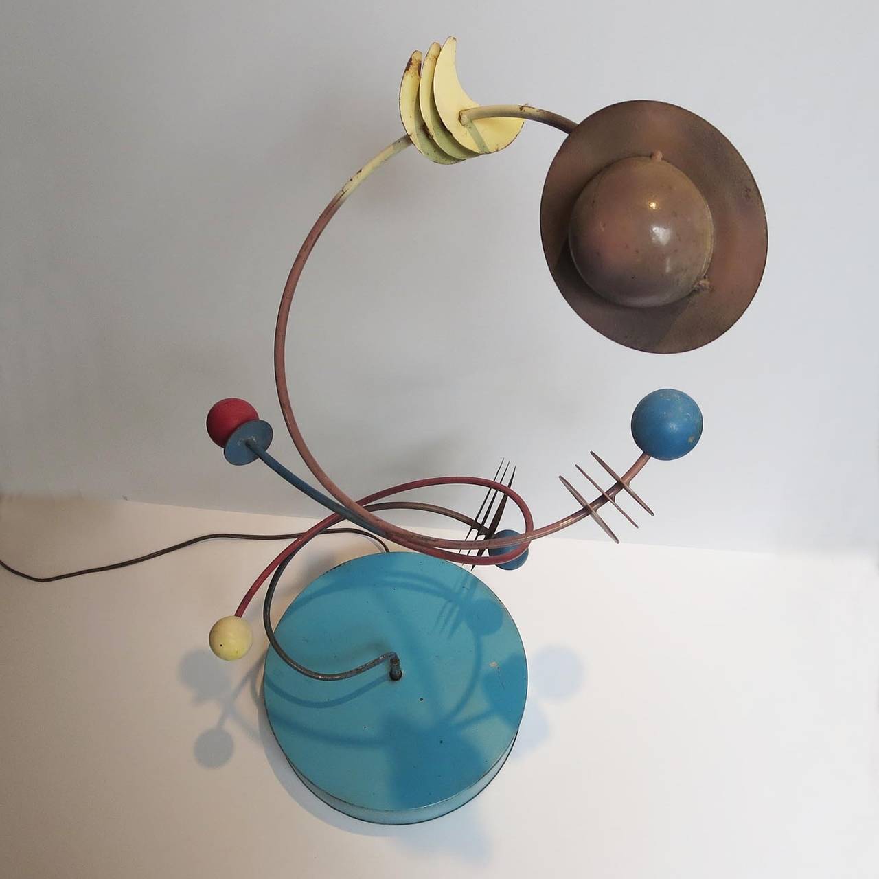 I have had many artistic and decorative items by Jere over the years, but nothing quite as unique as this! The sculpture represents a celestial grouping of planets and moons, created in painted wood and steel. The entire sculpture slowly revolves