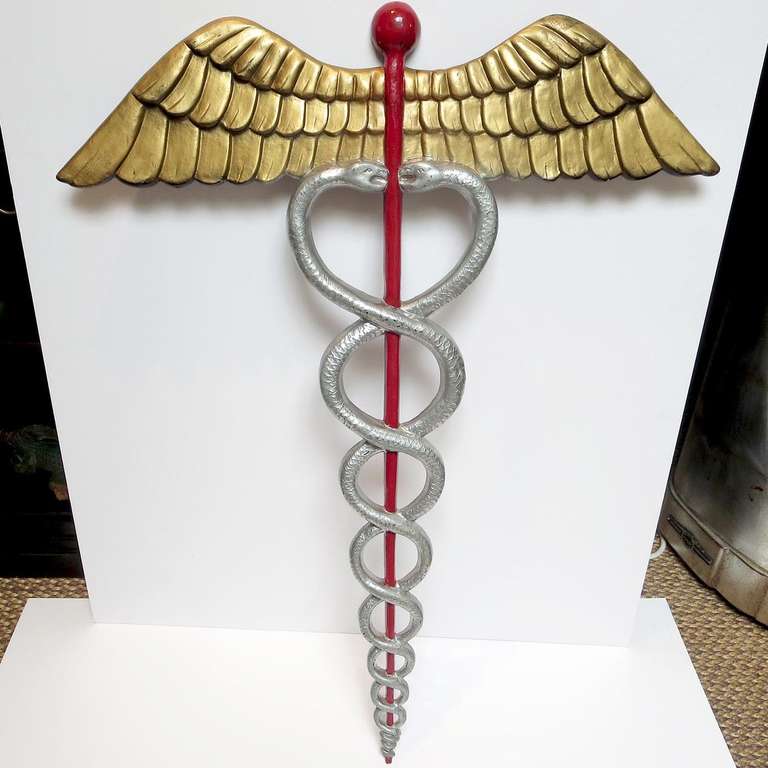 This wonderful and stylized cast aluminum plaque once hung outside a medical building. It has been repainted a few times, with the current finish done some time ago. The casting is very fine, with no damage or breaks. There are a series of small