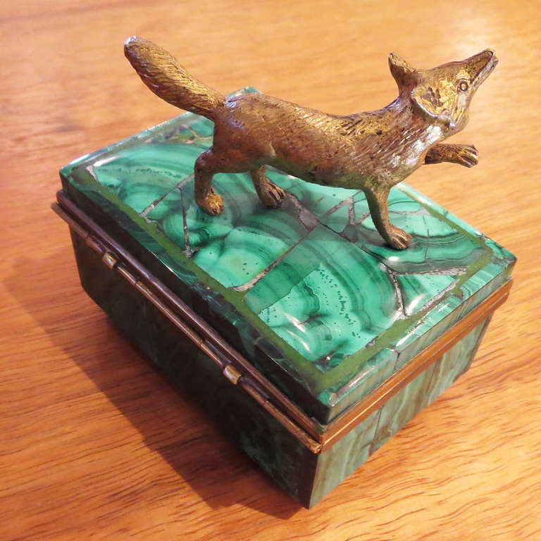 This charming box will look great in any setting. A silvered bronze fox acts as a handle on the top, opening up to reveal a velvet lined interior. There is also a mirror on the underside of the top. The malachite is sectioned in a mosaic fashion,