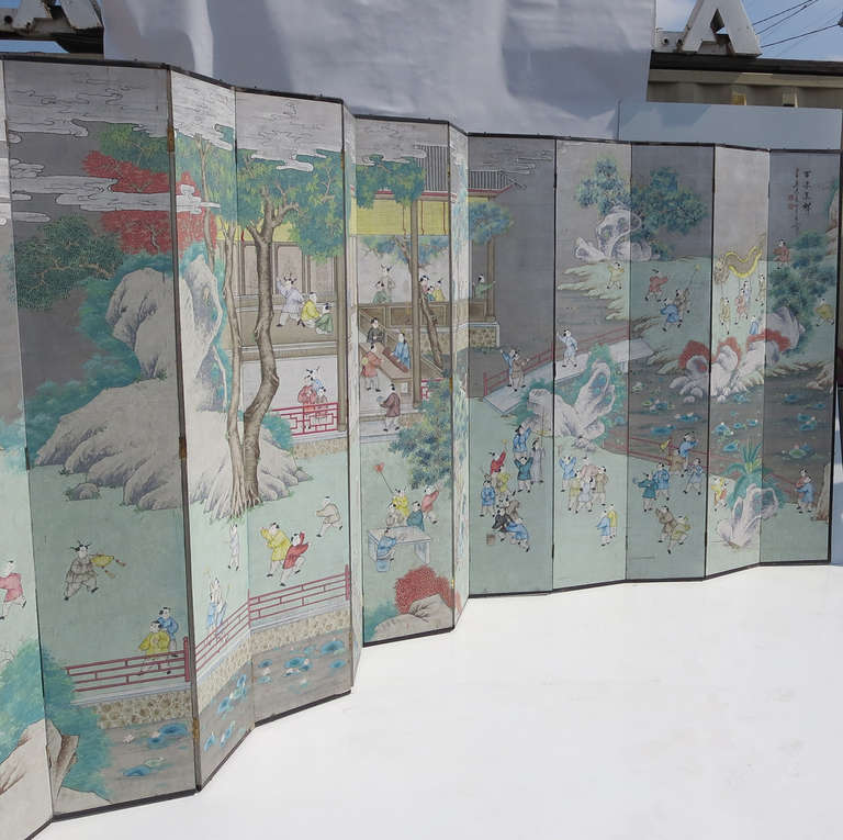 This great screen is the largest we have seen, with a total of twelve panels. The panels are hand painted paper, attached to a wooden board. The surface is colorful, with great activity depicted. There are a few areas of slight wear to the finish,