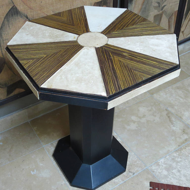 This tasteful table is most likely French in origin, circa 1930s. The top surface is a pinwheel design of alternating panels of Maccasar ebony wood, and shagreen leather. The base is black ebonized wood. All finishes are original, and show only the