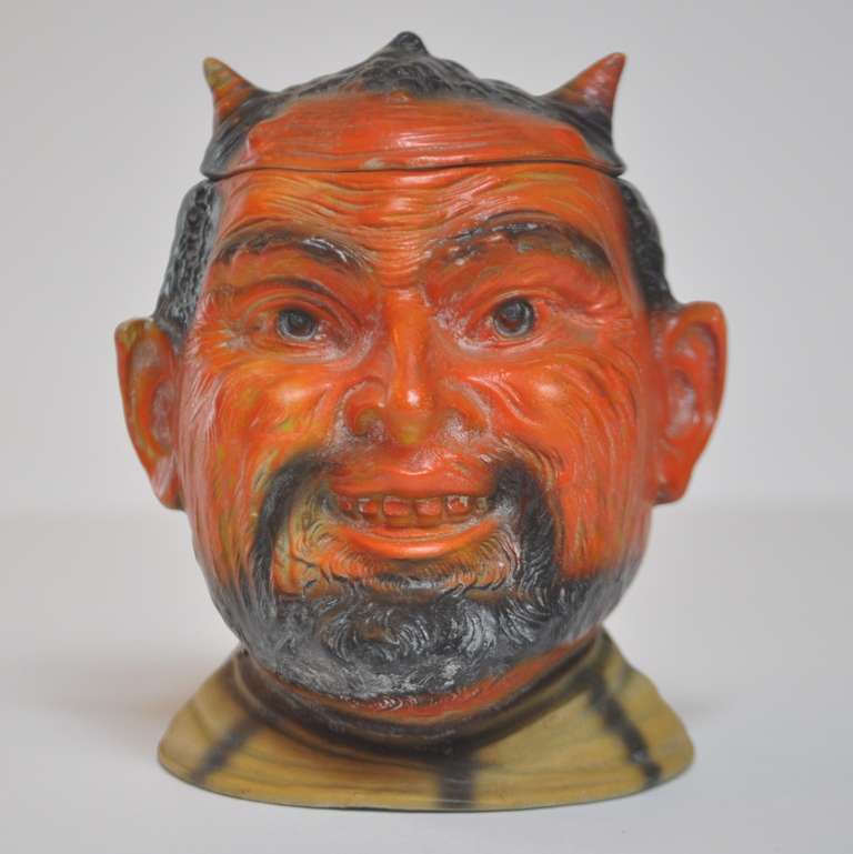 Devilish, indeed! In the early Twentieth century, the image of the devil was used on items pertaining to liquor, gambling, and tobacco - all Satan's vices! Our red faced fiendish friend was used to hold tobacco. He is a very fine, thin walled bisque