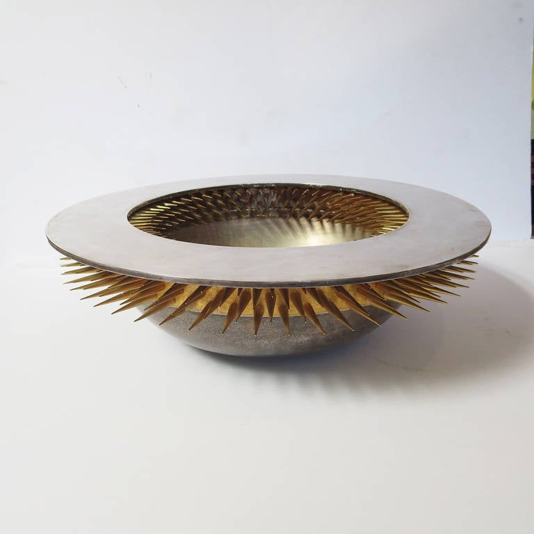 A fantastic and enticing sculptural bowl by Asian American artist Richard Mafong (born 1942). The bowl was executed in 1993, and is number 3 of 30 produced. The surfaces are silver and gold plated. The spikes extend two inches out from the wall of