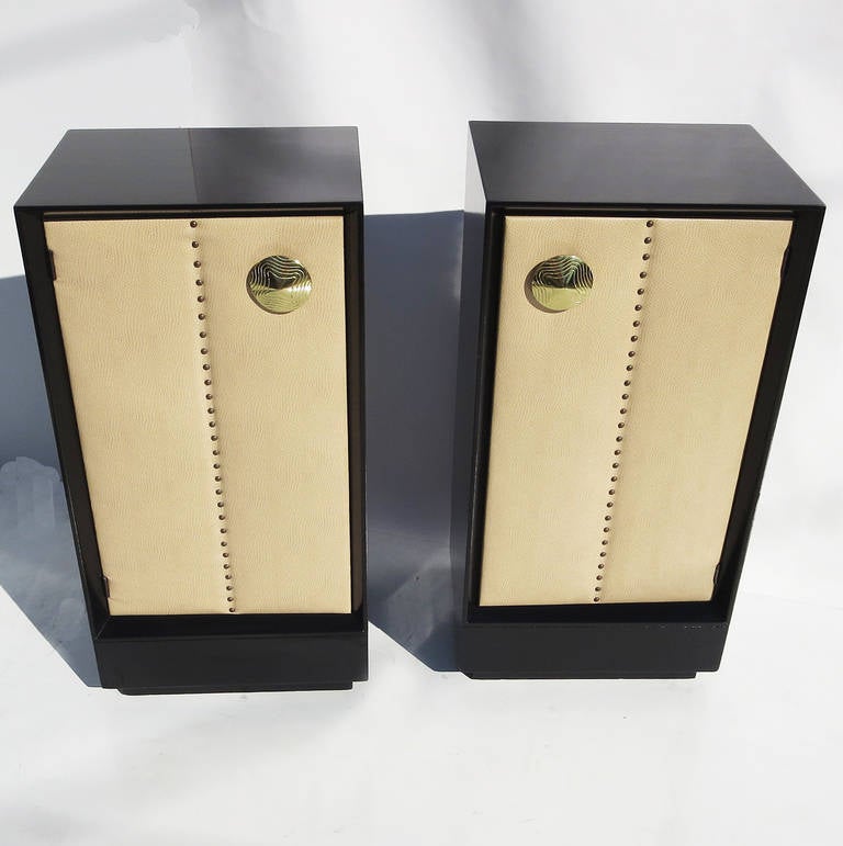 A wonderful and rare design by Rohde. These were offered in open book shelf style, or with a wooden or upholstered door. Ours are a matched pair, with left and right facing doors. The cabinets have been refinished in a satin black lacquer, and the
