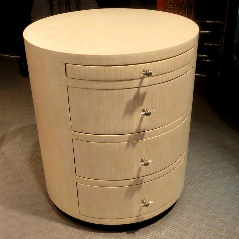 This lovely circular cabinet is quite versatile, and can be used in a variety of settings. All surfaces are finished in tiled and polished horn. The drawer pulls are nickeled metal and lucite rods, and add a tasteful decorative element. Even the