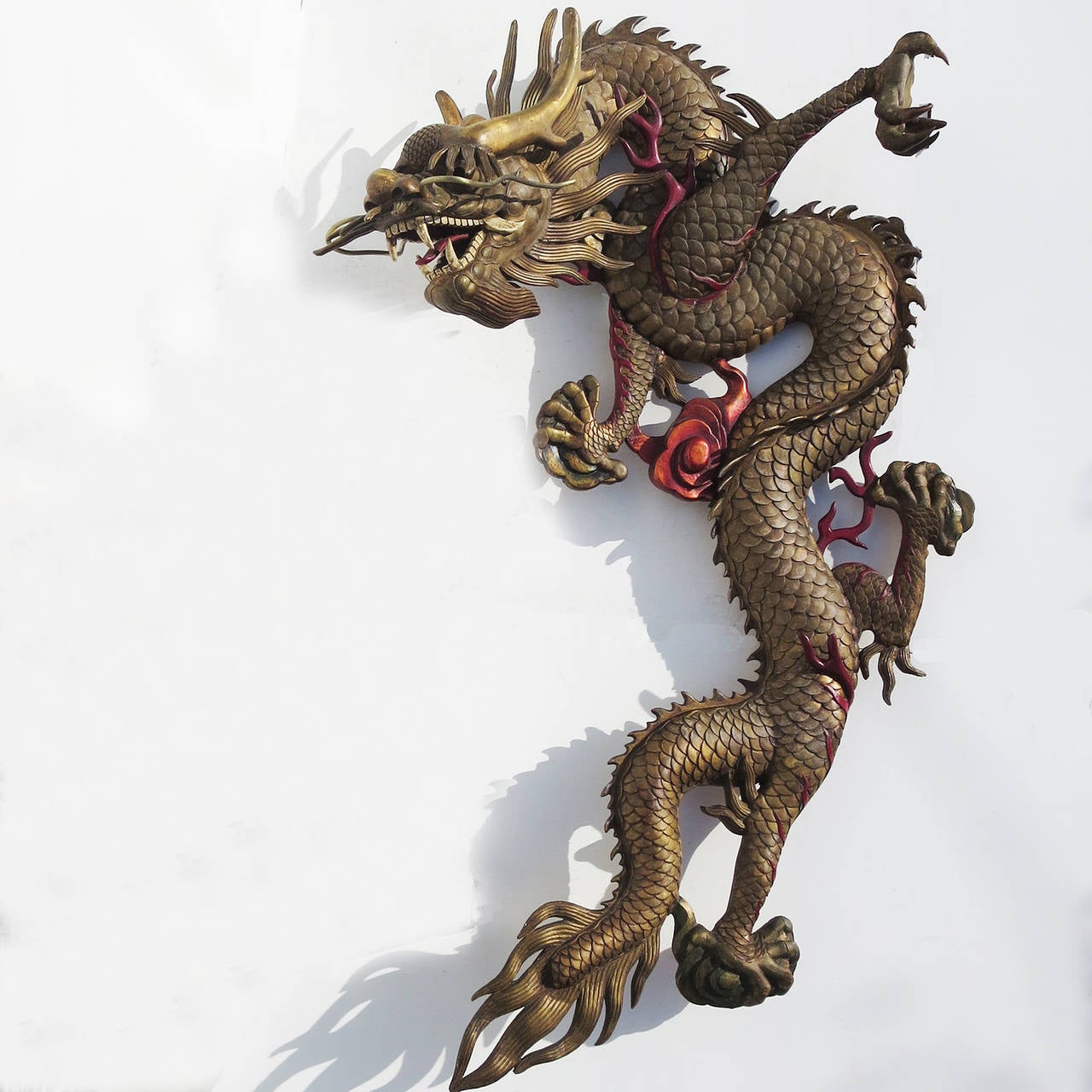 A fantastic depiction of a Chinese dragon in an impressive scale. Most likely made for a Chinese themed theater or restaurant, the figure is completely carved of wood, and finished in a gold painted surface. The finish has darkened over the years to