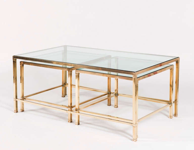 Three-piece brass frame table with square joints, inset glass top, and two recessable segments.