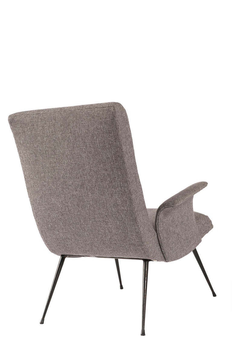 Pair of Italian club chairs with pad seat and back, moulded splay arms on canted iron legs, upholstered in grey flannel.