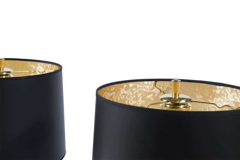 Leather-wrapped table lamps on splayed three leg brass base.