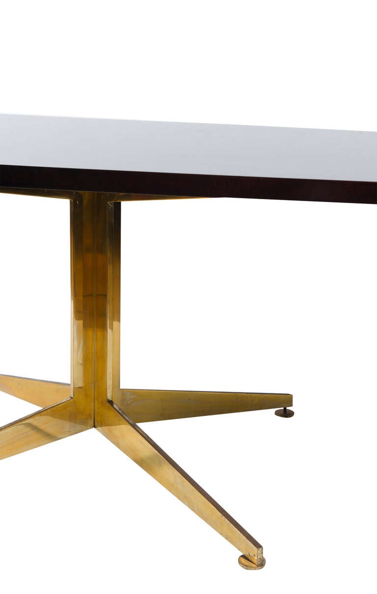 Rectangular lacquered black table resting on splayed brass base.