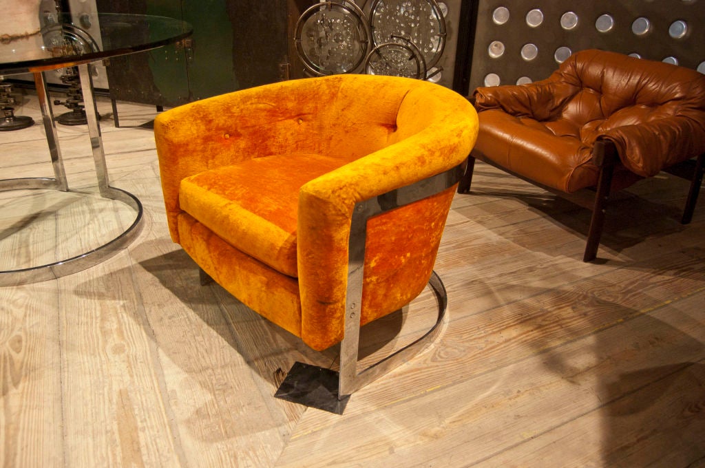 Pair of Milo Baughman barrel back chairs in original orange velvet upholstery resting, via screws, on chromed steel u-form frame