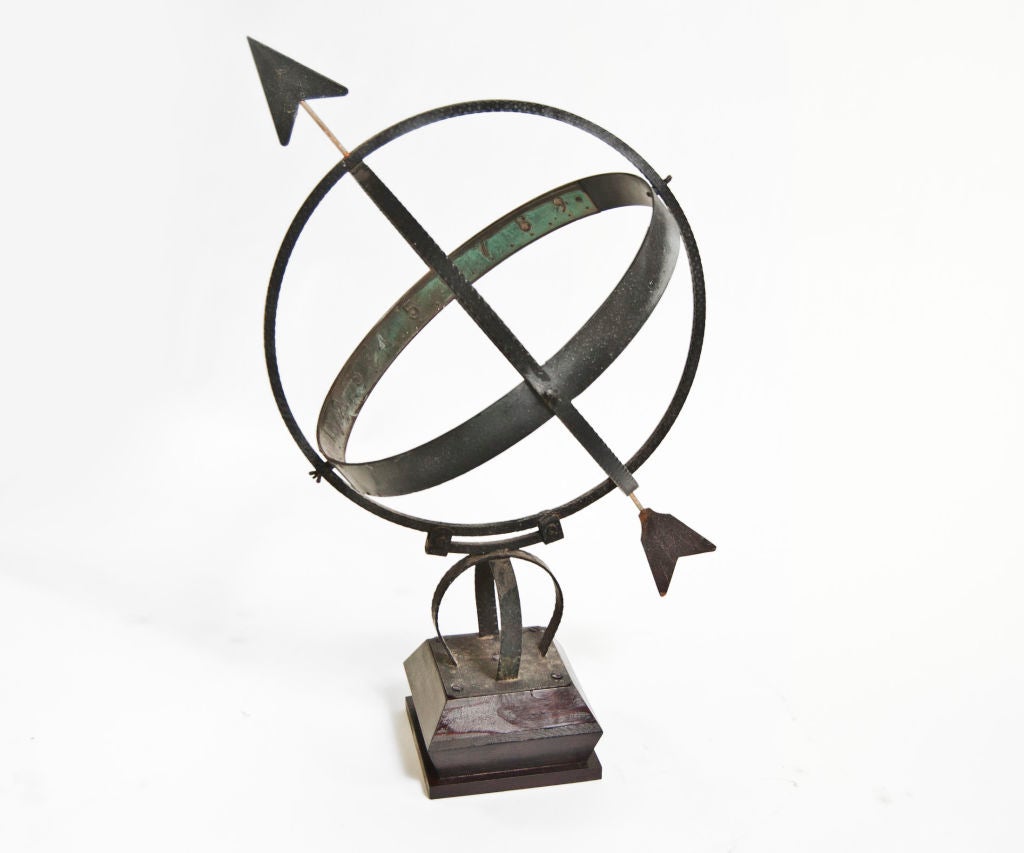 Vintage Swedish sundial in brass with natural patina, forged rings, and simple arrow on rich mahogany square footed base.