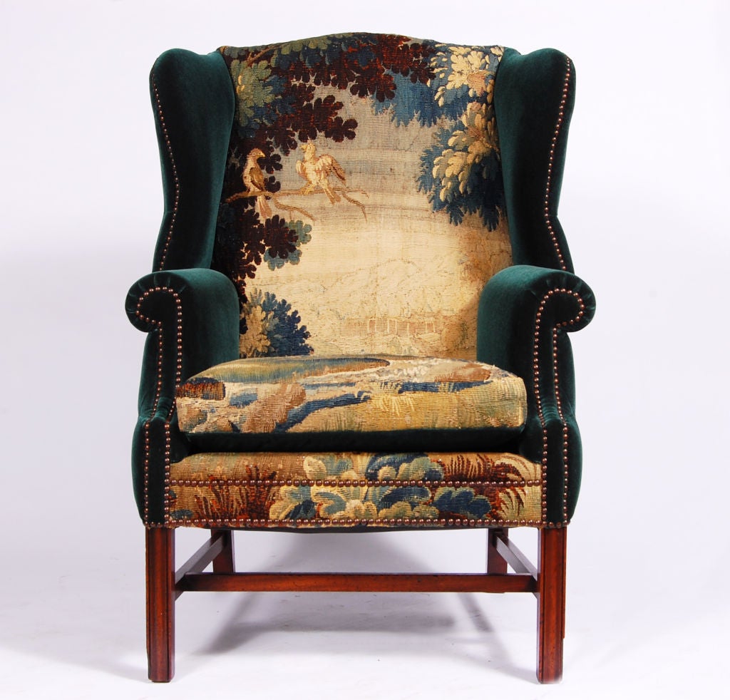 George III Style mahogany wing back chair re-upholstered in early 19th Century avian Swedish tapestry and meticulously quilted back in Holland & Sherry Agean Blue Mohair Velvet, chamfered square legs joined by H-from stretcher.