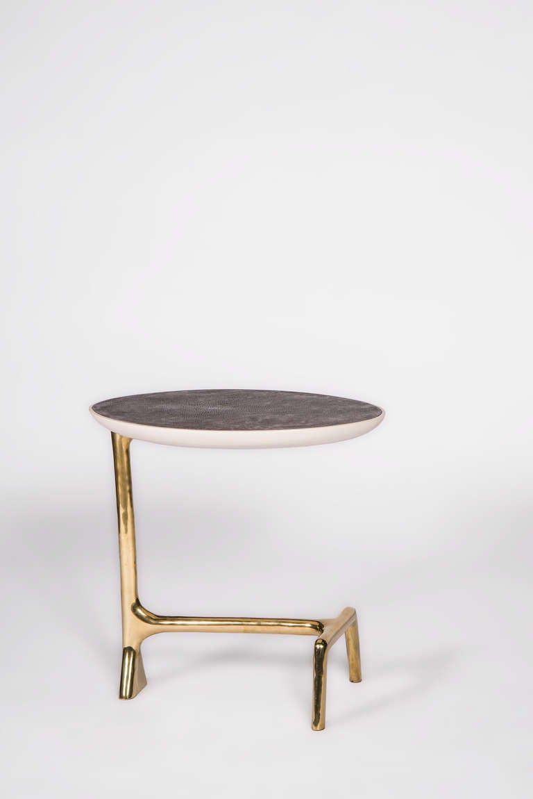 Side Table with polished cast brass base carved mahogany top covered in shagreen with white lacquer underside.