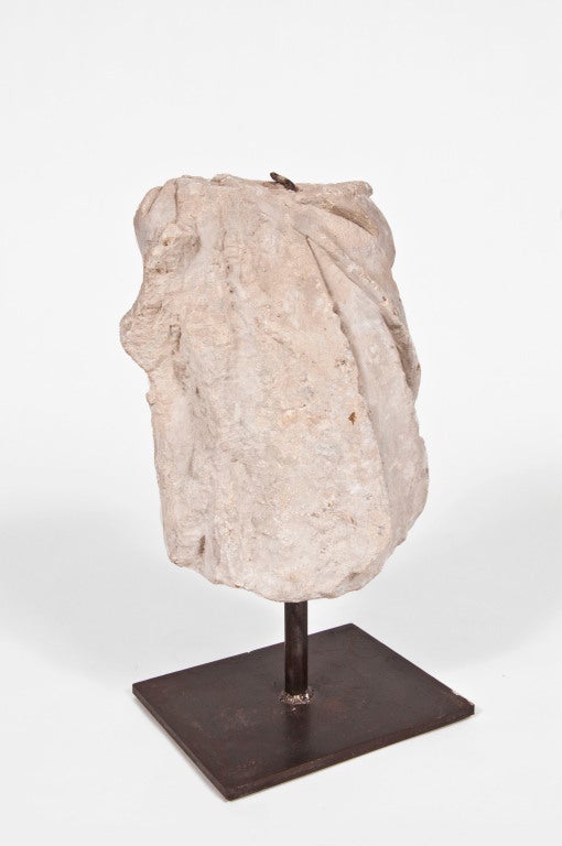 Carved stone sculpture of a draped bust on custom steel stand.