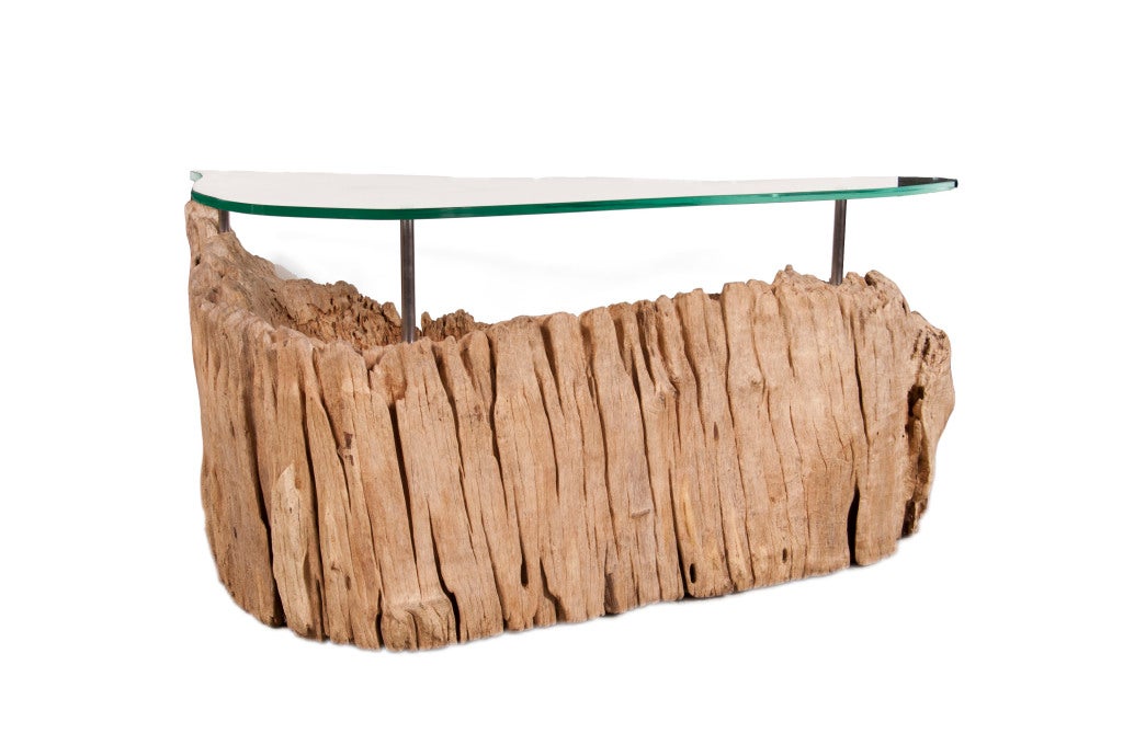 Organic root form with three brushed steel pins hoisting organic glass form top.