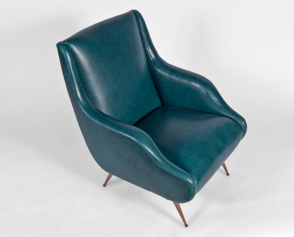 Pair of retro-modern style arm chairs attributed to Marco Zanuso, in the manner of the ‘Lady’ chair. Newly reupholstered in peacock blue vinyl, wavy arms, atop splayed turned brass legs with endcaps.