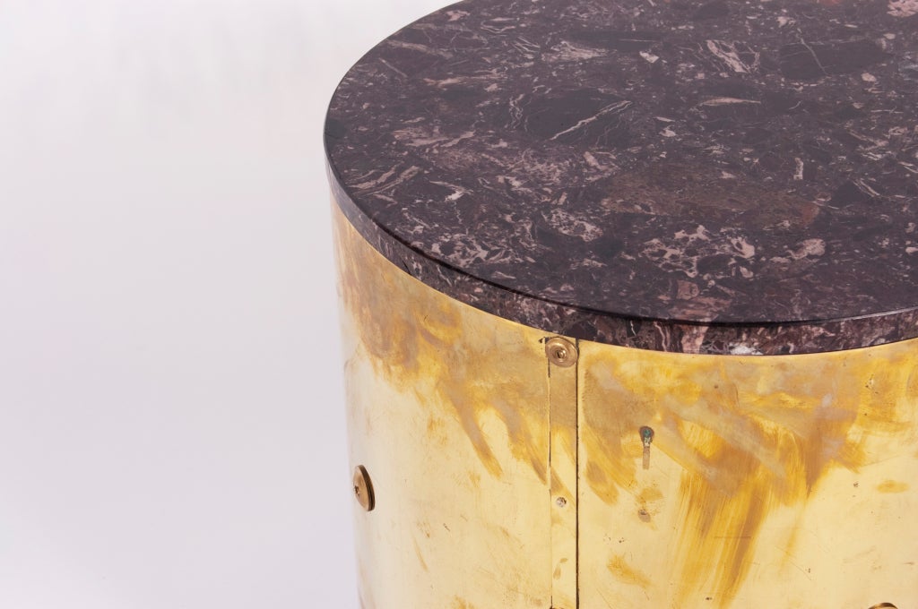 Pair of wooden frame cylindrical side tables with marble top brass wrapped brass sides with rivet detail on recessed base. Priced per pair.